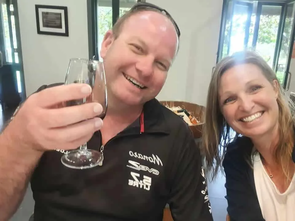 Two smiling guests sharing a cheers over a red wine tasting at a Hunter Valley cellar door