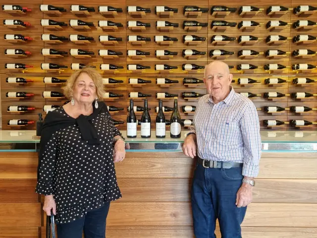Two guests in front of a floor-to-ceiling wall of wine bottles