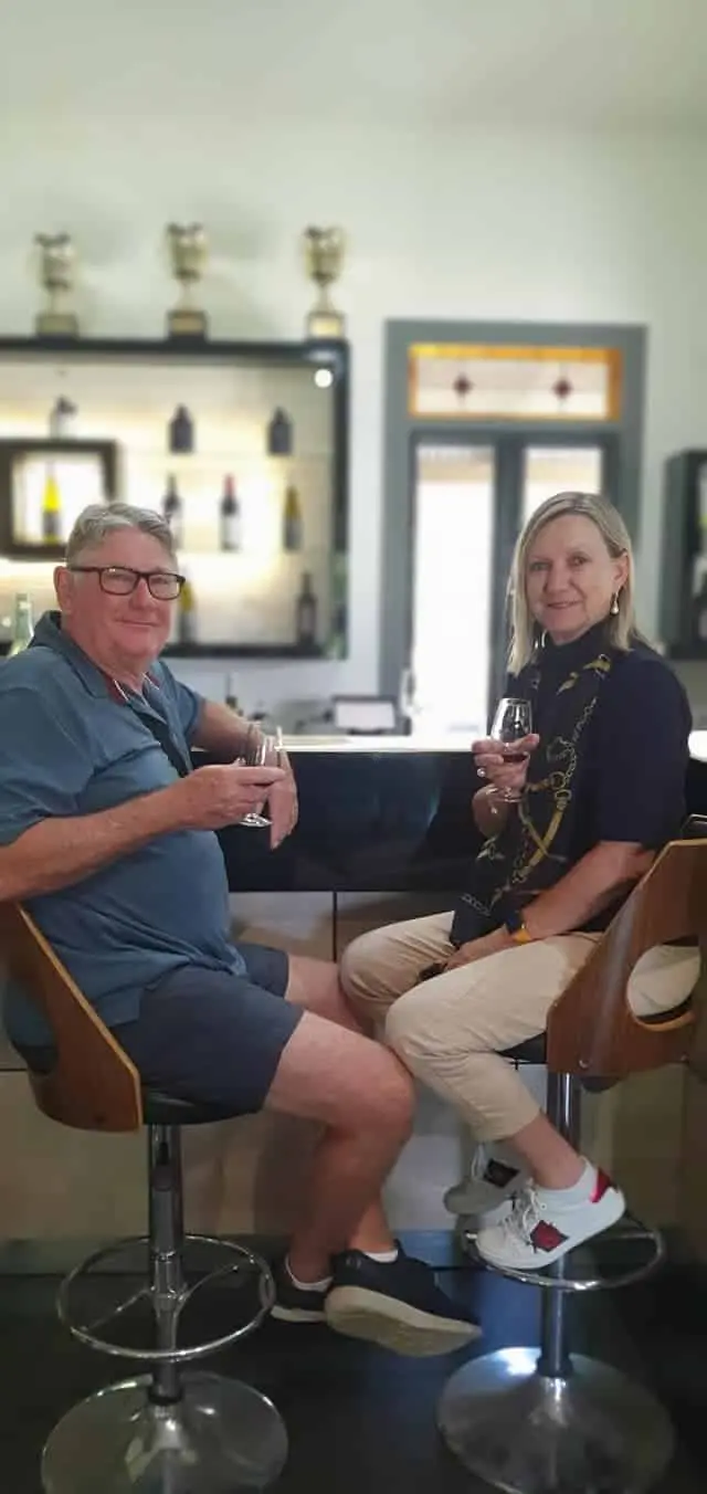 Two guests on stools at a bright cellar door counter