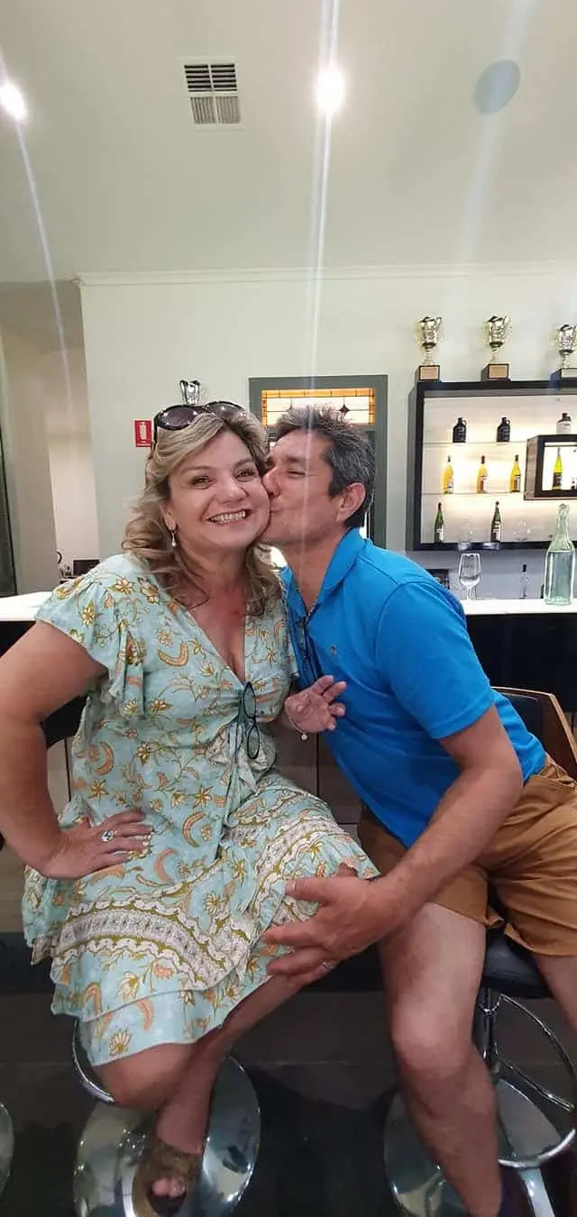 A couple sharing a moment at a cellar door tasting bench