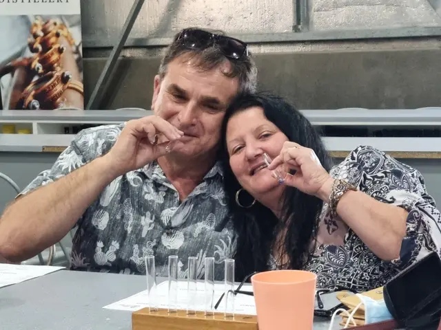 A couple being playful over their glasses at a tasting bench