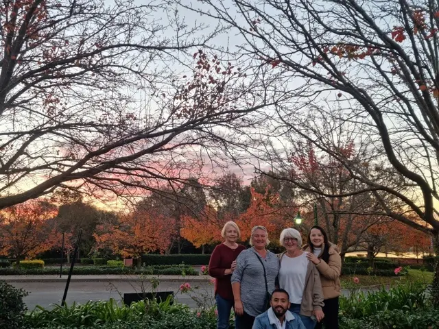 Guests together under an autumn tree as the light drops