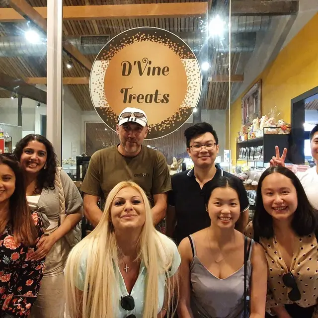Guests posing under the D'Vine Treats sign