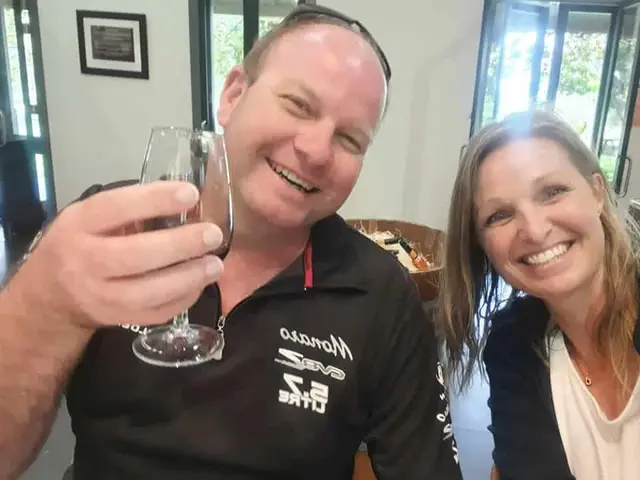A guest holding up a glass in a selfie with a guide