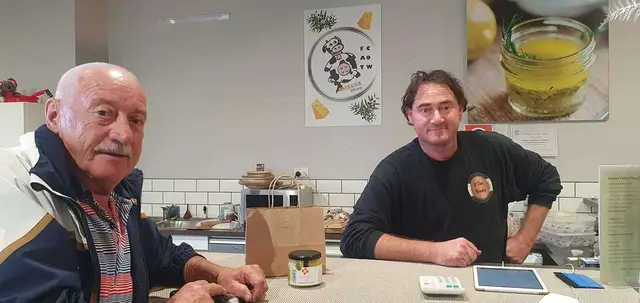 A guest chatting with the maker at a small tasting counter