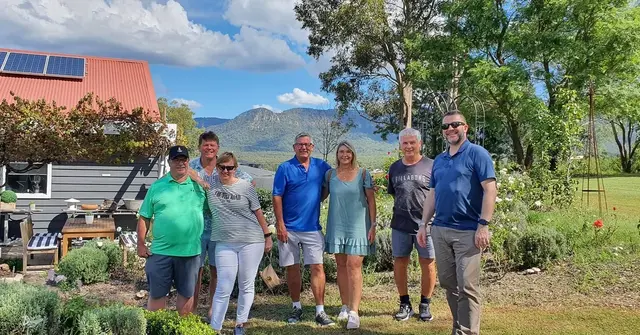 Guests in a cellar door garden with the range behind them