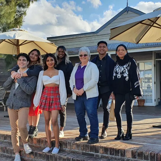 Guests on a cellar door deck under big umbrellas