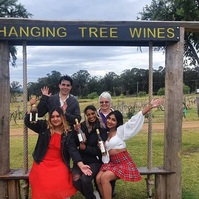 Guests under the Hanging Tree Wines arch holding up their bottles