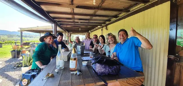 Guests along a long table on a corrugated-iron verandah