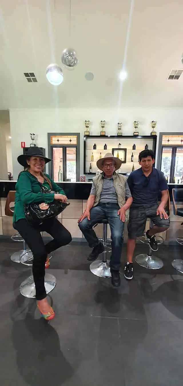 Three guests on stools in a modern tasting room