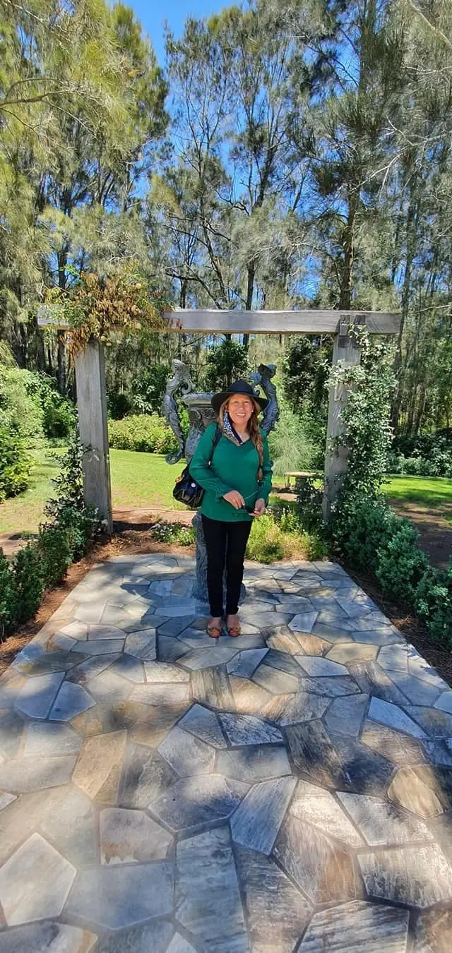 A guest on the stone path under a cellar door garden arch
