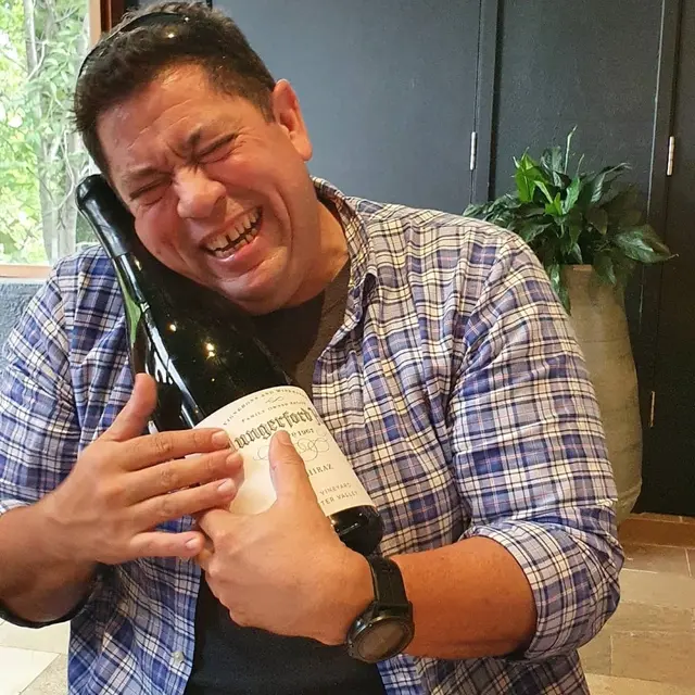A guest hugging an oversized bottle after a tasting