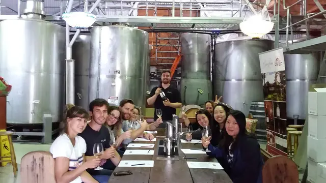 Guests tasting at a table among the stainless steel tanks
