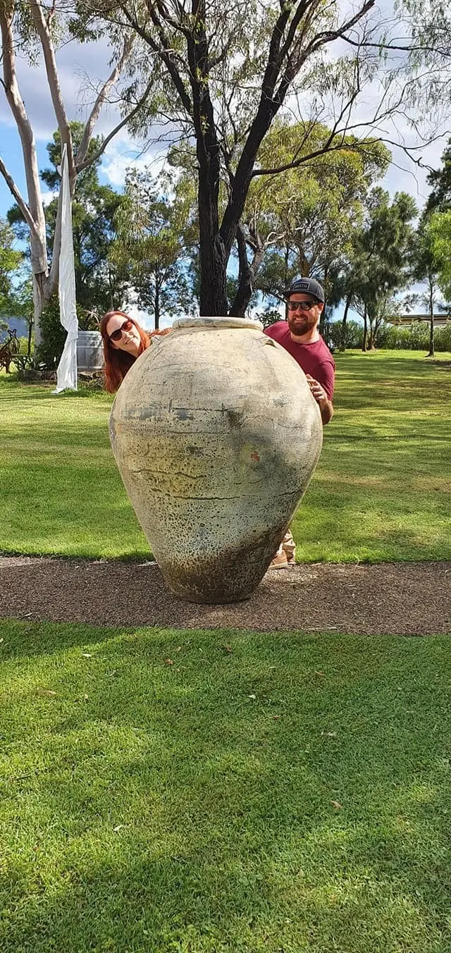 Two guests beside a giant ceramic urn on a cellar door lawn