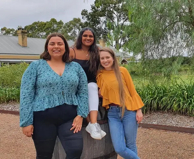 Three guests beside a barrel in a cellar door garden