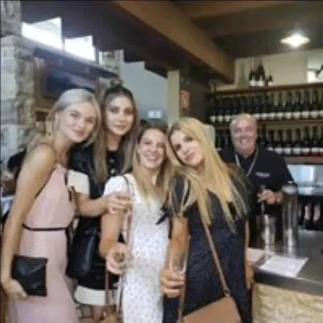 Guests raising their glasses at a busy tasting counter