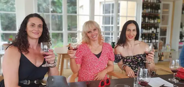 Three guests toasting at a tasting table