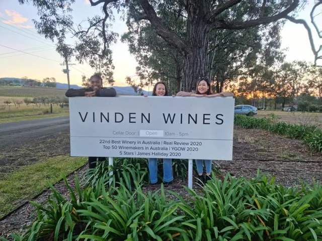 Three guests posing at the Vinden Wines roadside sign