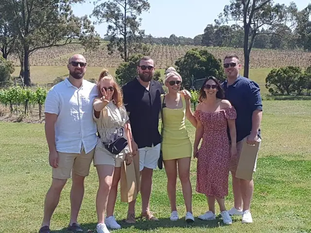 A group on the lawn with the vineyard rows behind