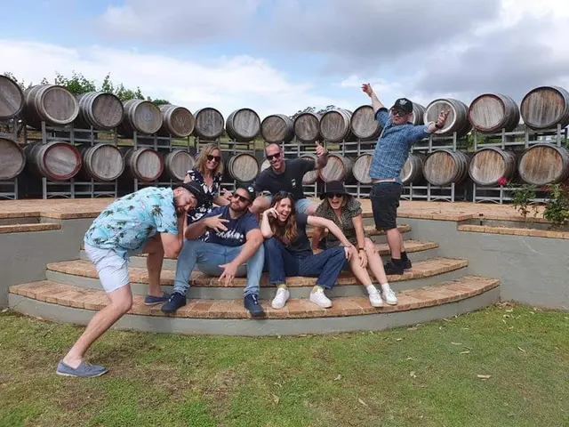 Guests posing on the steps in front of a wall of barrels