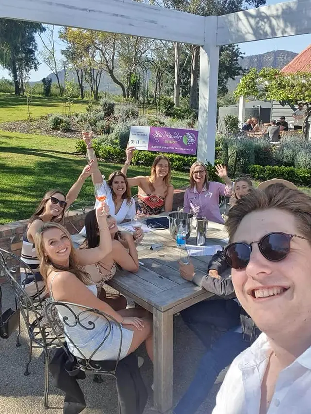 A selfie from an outdoor table stop with the rest of the group behind