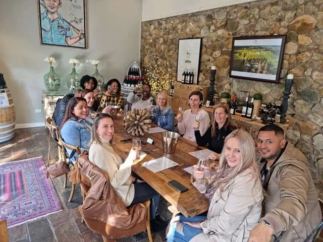A large group along a table in a stone-walled cellar door