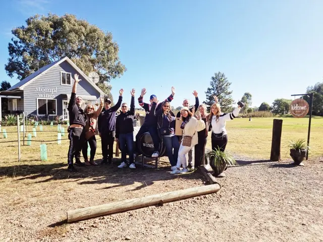 A group with arms up on the forecourt of a small cellar door