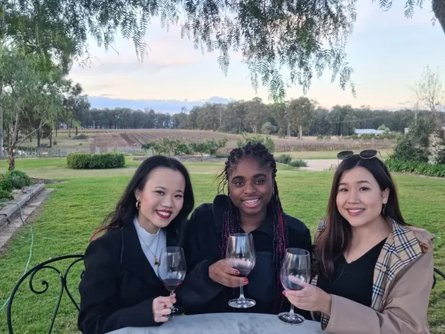 Three guests toasting at a garden table