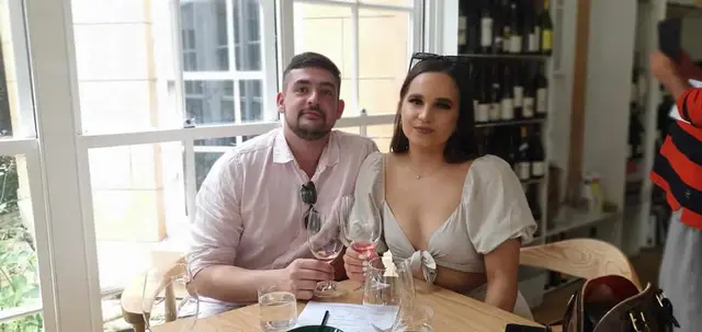 A couple at a window-side tasting table