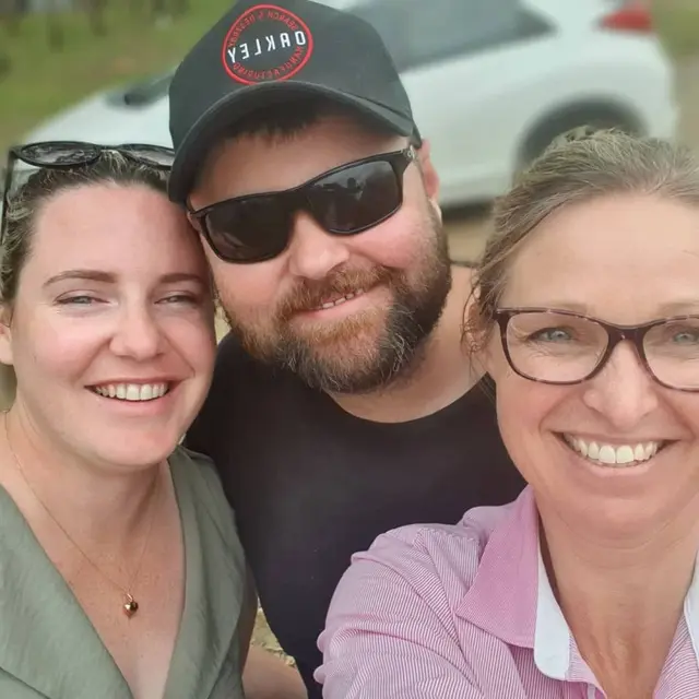 A guide and two guests in a close selfie