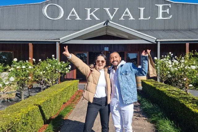 Two guests pointing up at the Oakvale sign
