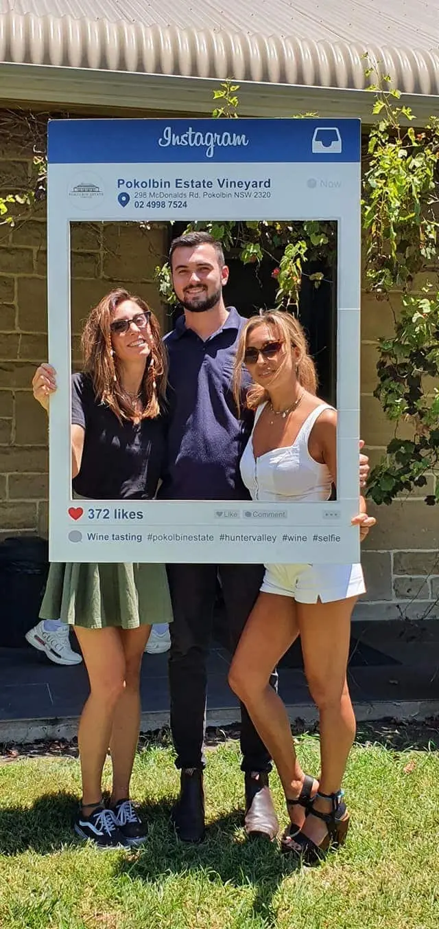 Three guests posing inside a giant photo frame prop