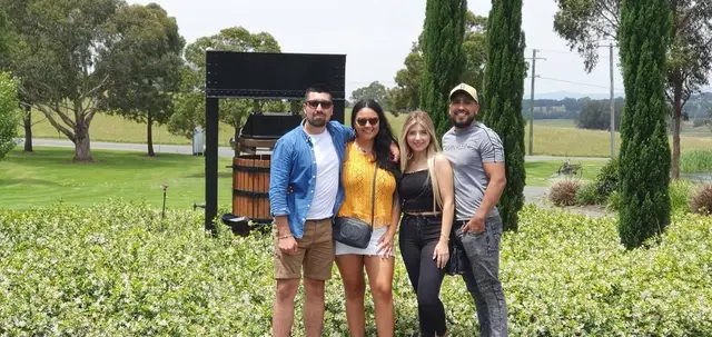 Four guests beside a cellar door entrance sign