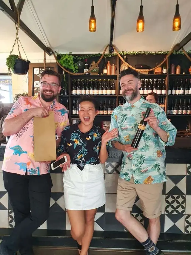 Guests at a bar with the bottle and bag from their tasting
