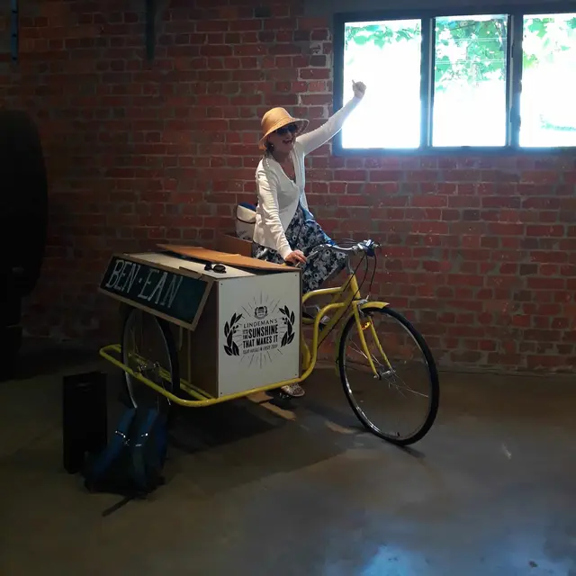A guest riding a vintage delivery bicycle inside a cellar door