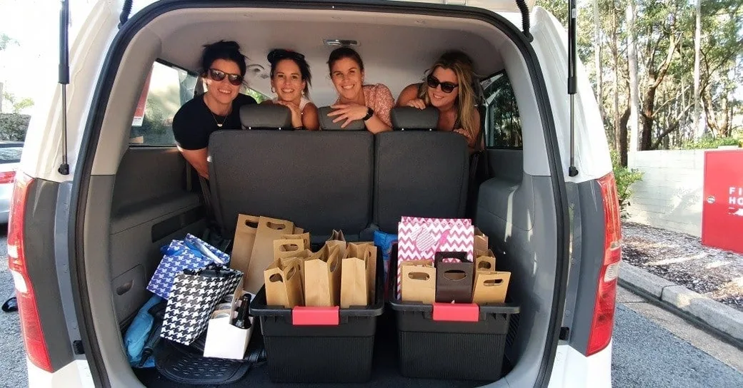 Guests smiling from the back of the Hunter Valley Tours van beside the day&rsquo;s cellar door purchases